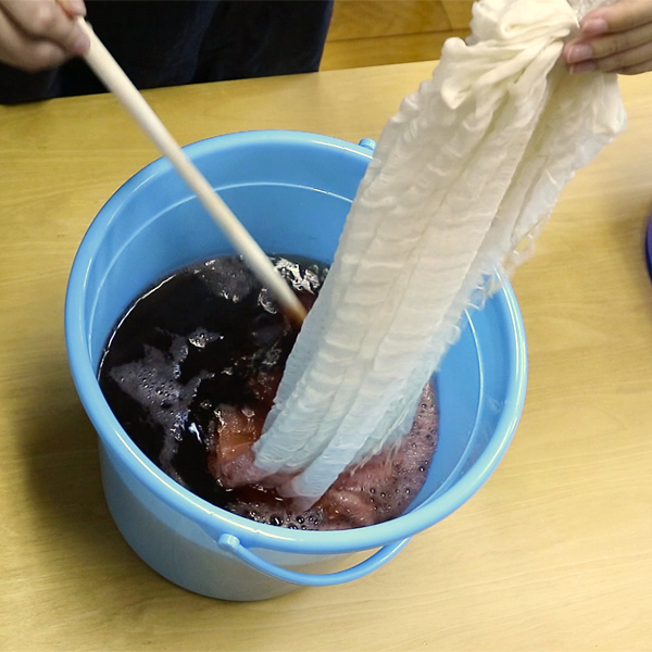 染料に生地を浸して染色します