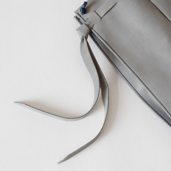 ひらひらと揺れるサイドの革紐がアクセントに