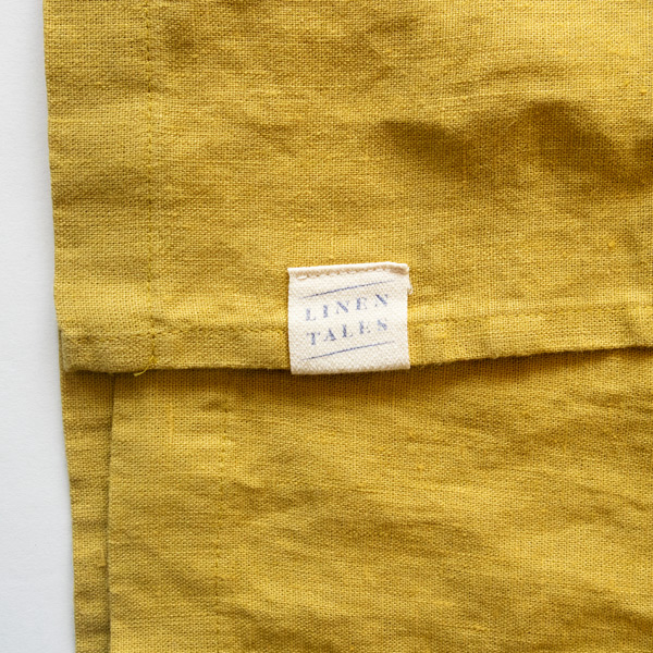 LINEN TALESのブランドロゴが裾の近くに(LEMON CURRY)