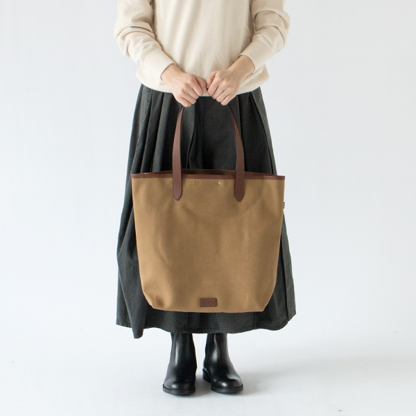 すっきりと洗練された縦型のトートバッグ(KHAKI、身長162cm)