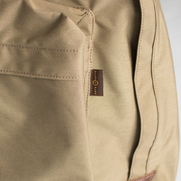 前面のサブポケットにはロゴ入りタグがついています(DARK BEIGE)