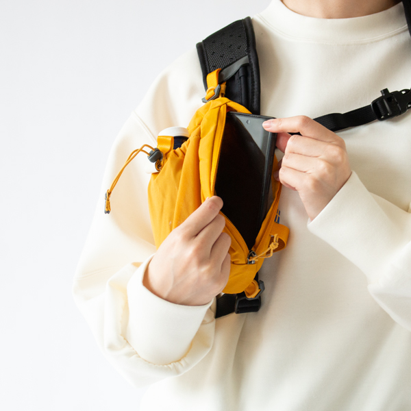 スマートフォンや行動食などを収納できるジッパー付きポケット(Mustard Yellow)