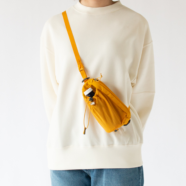 取り外し可能なストラップを使うことで、クロスボディバッグとしても活躍(Mustard Yellow)