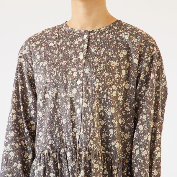 品のある胸元のボタンとプリーツのディテール 品のある胸元のボタンとプリーツのディテール