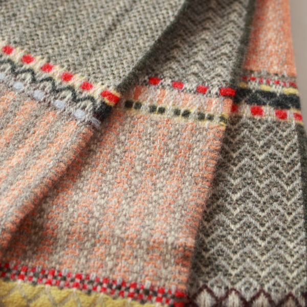 やわらかなピーチトーンに、レッドやイエロー、ラベンダーの差し色が映えるスカーフ。グレージュとチャコールの繊細なストライプが全体をやさしく引き締めます(PEACH)