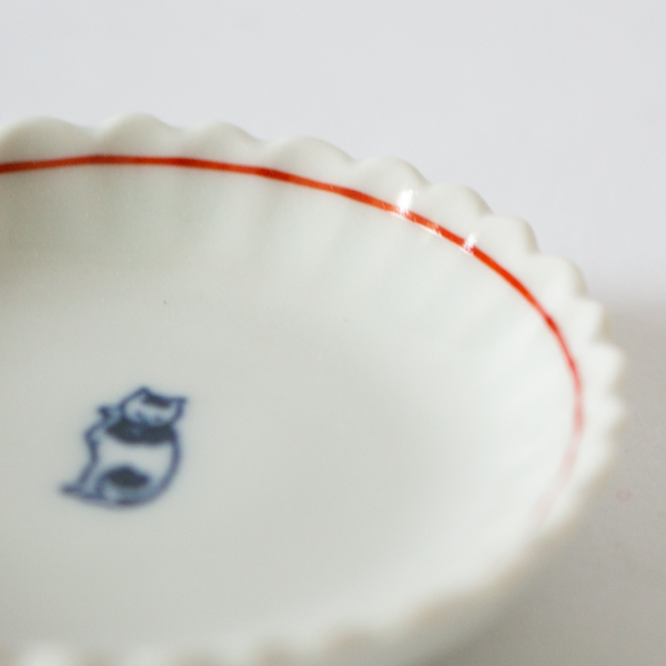 菊の花が広がるような縁のデザインに赤いライン