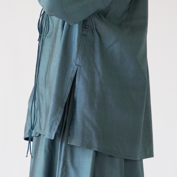 サイドには深めのスリットを施し、歩いたり座ったりといった動作もスムーズに(ディープグリーン)