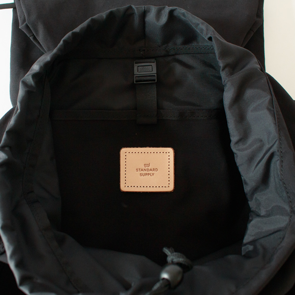 メイン収納分にはヌメ革のロゴのタグがあります。