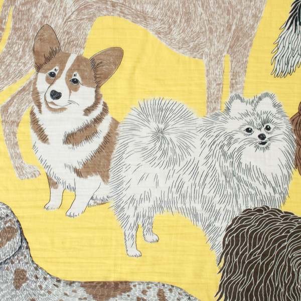 やわらかなイエローを背景に、さまざまな犬たちを描いたコットンストール